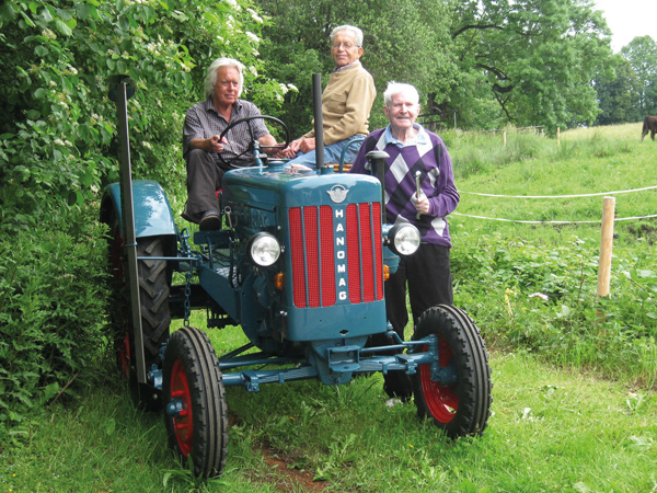 Drei Senioren auf dem restaurierten Traktor