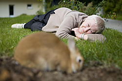 Alte Frau liegt im Gras und betrachtet einen Hasen © Thomas Hagedorn, Quelle: konfetti-im-kopf.de