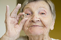 Eine alte Frau hält eine Ausstechform für Plätzchen in ihrer Hand und betrachtet sie © Thomas Hagedorn, Quelle: konfetti-im-kopf.de