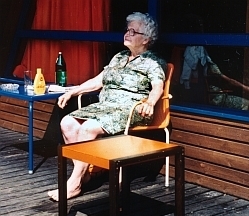 Eine alte Frau sonnt sich auf einem Balkon